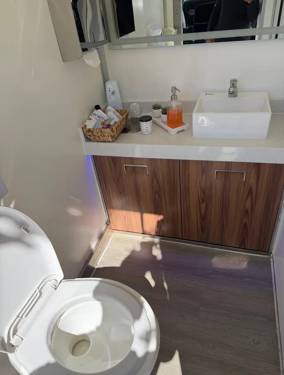 Restroom trailer vanity with vessel sink, soap and wood cabinet