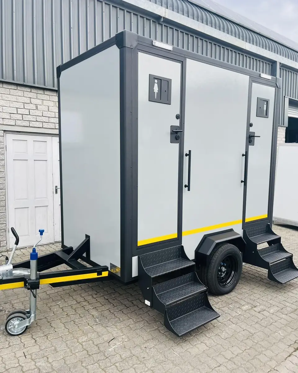 Two-station restroom trailer with separate doors and fold-down steps